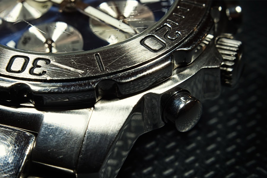 stainless steel watch showing visible scratches and cracks