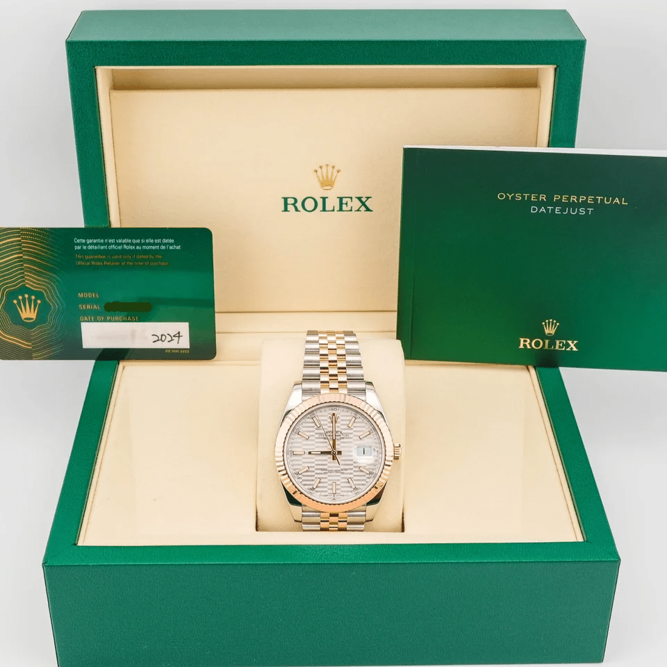 The Rolex Datejust Steel and Rose Gold with a Silver Fluted Motif Dial 126331 combines timeless elegance with classic Rolex luxury. Its Oystersteel and 18k Everose gold construction creates a warm and sophisticated appearance. As a result, this Rolex Datejust remains a distinctive choice for collectors and enthusiasts. The 41mm Oystersteel case offers balanced proportions with a strong presence on the wrist. Its fluted 18k Everose gold bezel adds texture and a distinctive Rolex touch. Meanwhile, the Jubilee bracelet provides a comfortable fit with its elegant five-link design. The silver fluted motif dial creates a refined and distinctive appearance. Its intricate pattern adds depth while complementing the warm Everose gold details. A date window sits at 3 o’clock beneath the signature Cyclops lens for easy reading. The Rolex 126331 is powered by the automatic Caliber 3235 movement. It delivers precise timekeeping and reliable date performance for everyday wear. Overall, the Rolex Datejust 126331 captures the timeless appeal of the Datejust collection. Its Oystersteel case, Everose gold fluted bezel, silver motif dial, and Jubilee bracelet create an elegant combination. Therefore, it makes a prestigious addition to any fine Rolex collection.