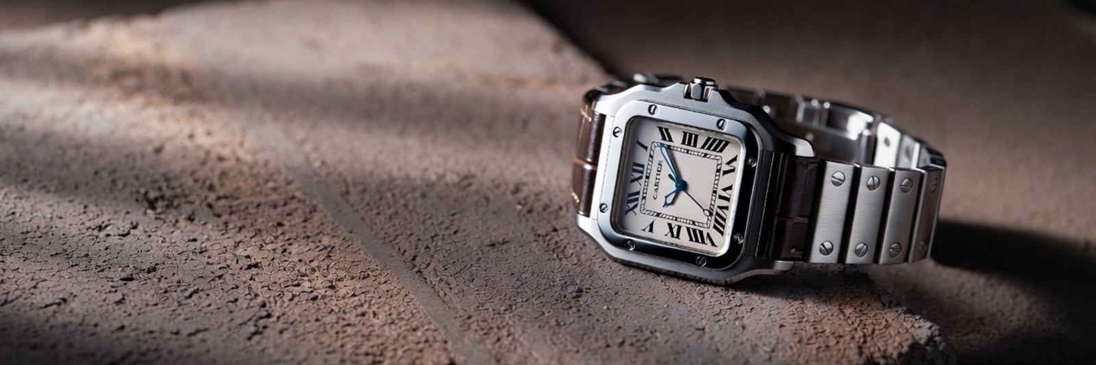 cartier santos watch on concrete surface