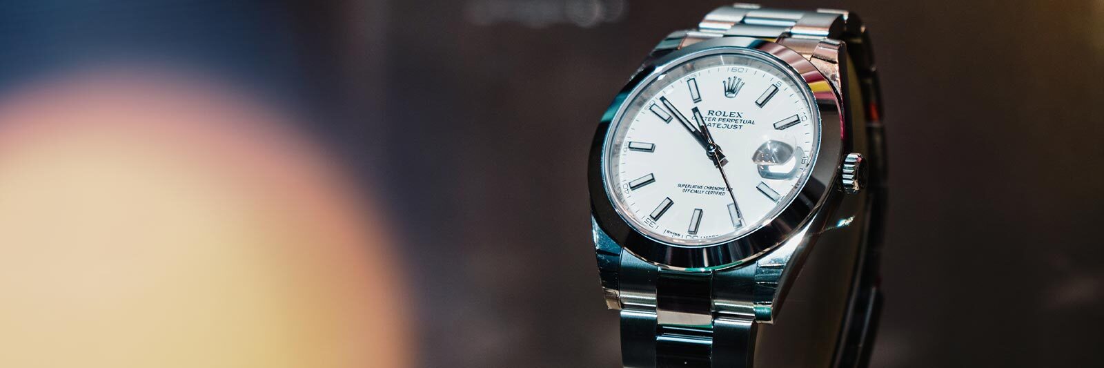 silver rolex watch on an abstract background