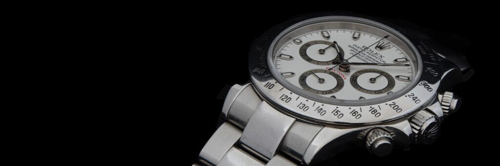 silver rolex daytona on black background