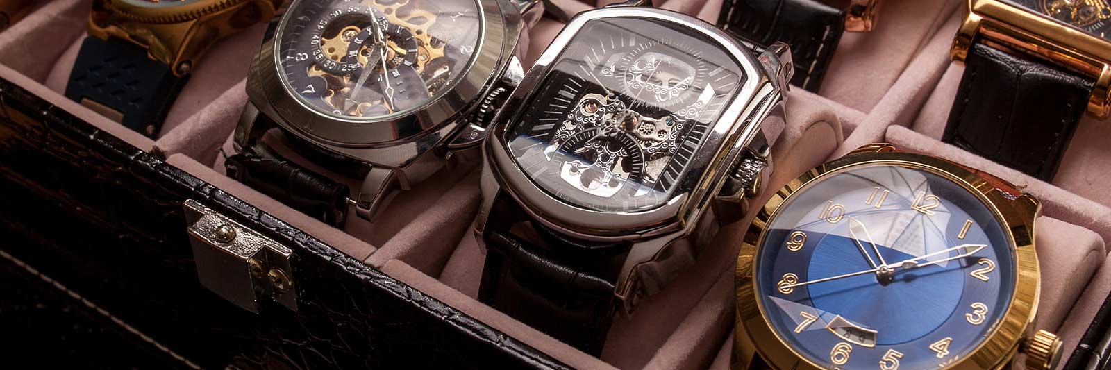multiple luxury watches in a watch storage box