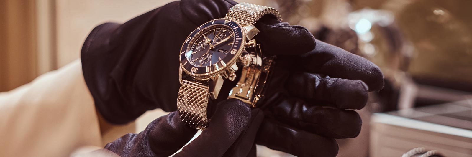 watch authenticator holding a gold luxury watch