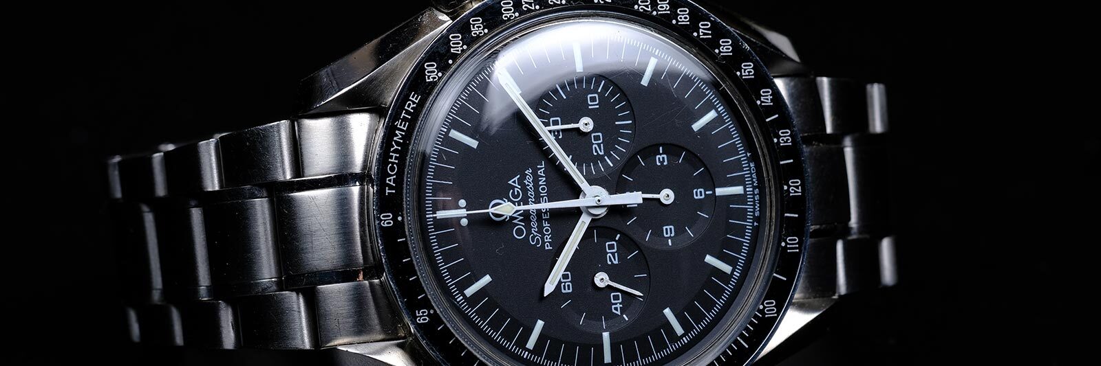 stainless steel omega watch laying on its side